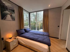 a bedroom with a bed and a large window at Detached Hoenderloo veluwshof in Hoenderloo +14 photos