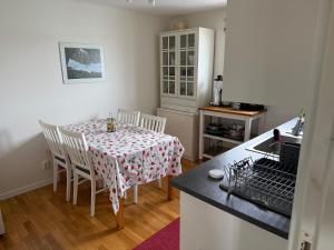 a kitchen with a table and chairs with a table and a counter at Lägenhet 2 sovrum med vardagsrum och kök i villa med gemensam ingång in Stockholm
