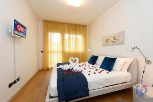 a bedroom with a white bed with red flowers on it at The Wind Rose renovation 2025 DesenzanoLoft Official Partner Homes & Villas by Marriott Bonvoy in Desenzano del Garda