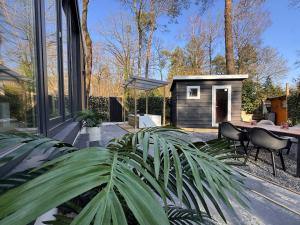 a backyard with a tiny house with a table and chairs at Detached Hoenderloo veluwshof in Hoenderloo