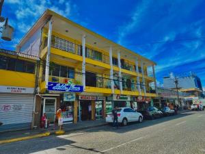 a yellow building on the side of a street at Hotel Miami CR in Puerto Limón