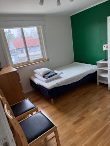 a small bedroom with a bed and a chair at Lägenhet 2 sovrum med vardagsrum och kök i villa med gemensam ingång in Stockholm