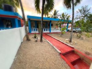 a blue and white building with palm trees in front of it at Villa Rosa in San Felipe de Puerto Plata