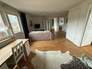 a room with a bedroom with a bed and a desk at Lägenhet 2 sovrum med vardagsrum och kök i villa med gemensam ingång in Stockholm