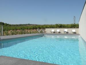 uma grande piscina com cadeiras em Luxury g te in a renovated farmhouse em Rieux-Minervois