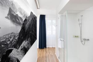 a bathroom with a mountain mural on the wall at Hotel Engel in Stans +29 photos