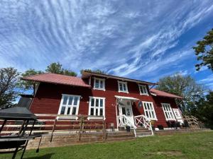 a large red house with a blue sky at Charming Bed & Breakfast - Villa Högby in Löttorp
