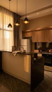 a kitchen with wooden cabinets and a black counter top at Lanai Villas Beach Side in Baku
