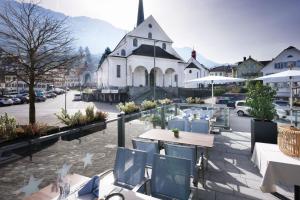 a view of a town with tables and chairs and a church at Hotel Engel in Stans