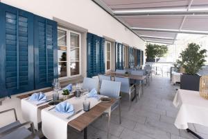 a restaurant with white tables and blue walls at Hotel Engel in Stans