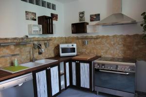 a kitchen with a stove top oven and microwave at B&B Gallidoro in Palermo