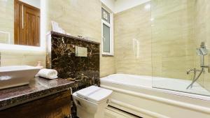 a bathroom with a tub and a toilet and a sink at BluO Medicity - Boutique Hotel Gurgaon in Gurgaon