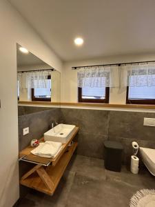 a bathroom with a sink and a mirror and a tub at Apartamenty na Rycerskiej in Czorsztyn