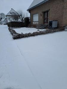a house with snow on the ground in front of it at Ferienwohnung Flip in Xanten