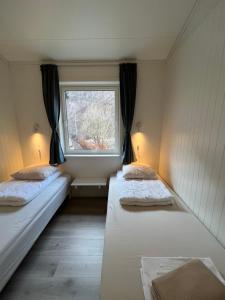 two beds in a room with a window at Trolltunga Camping in Odda