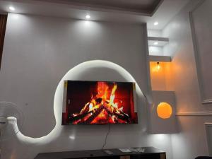 a fireplace in a living room with a tv on a wall at D2H résidence in Abidjan