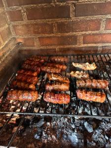 a bunch of sausages and other food on a grill at Casa Alexia in Potoc