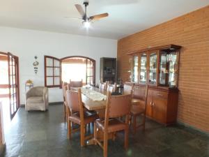 a dining room with a table and chairs and a brick wall at Casa da Vó Lucia in Serra Negra +19 photos