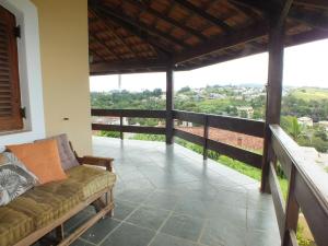 a living room with a couch on a balcony at Casa da Vó Lucia in Serra Negra