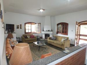 a living room with two couches and a fireplace at Casa da Vó Lucia in Serra Negra