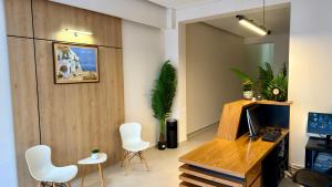 a living room with white chairs and a television at Hotel Metali - City Centre in Sarandë