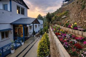 a house with flowers on the side of a hill at Serene Forest Resort in Nainital