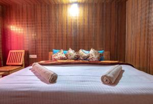 a bedroom with a large bed with towels on it at Pangong Mentsel Cottage in Lukung