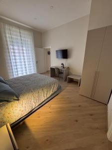 a bedroom with a bed and a desk and a window at Notte di note in Pagani