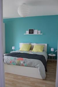 - une chambre dotée d'un lit avec un mur bleu dans l'établissement Gîte Céleste pour 6 personnes, à Mardeuil