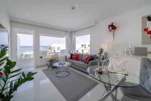 a living room with a couch and a glass table at Lani's Suites de Luxe - Adults Only in Puerto del Carmen