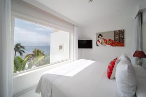 a white bedroom with a large window and a bed at Lani's Suites de Luxe - Adults Only in Puerto del Carmen +107 photos