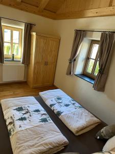 two beds in a room with a window at Ferienhaus Steinschlössl in Mühldorf