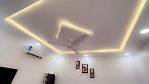 a room with a white ceiling with lights on it at SOALTEE Near Lucknow Airport in Lucknow +4 photos