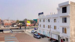 a white building with a car parked in front of it at SOALTEE Near Lucknow Airport in Lucknow