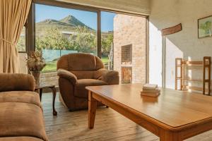 a living room with a couch and a table and a chair at Phillipskop Eco-Chalets in Stanford