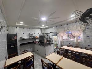 a kitchen with tables and chairs in a restaurant at Hotel Flor do Pari in São Paulo