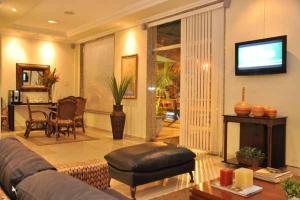 a living room with a couch and a television at Hotel Montana Serra Negra in Serra Negra