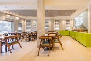 a dining room with wooden tables and green cabinets at Treebo Ace Luxe in New Delhi