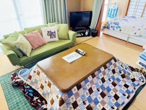 a living room with a couch and a coffee table at Yufu Inn in Yufu