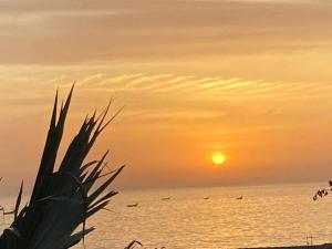 a sunset over the ocean with boats in the water at Résidence KEUR FLEURIE in Rufisque +14 photos