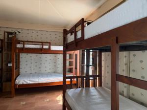 a room with three bunk beds in a house at The Wild Deck - Chikkamagaluru in Chikmagalūr