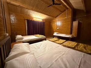 a bedroom with two beds in a wooden room at The Wild Deck - Chikkamagaluru in Chikmagalūr