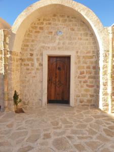 an archway with a wooden door in a building at Dar Zmen Toujane in Tūjān