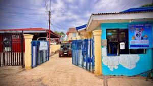 a blue building with a gate on a street at Dexter John's Guesthouse in Agus