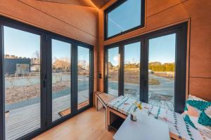 a room with large windows and a table at Romantic luxury tiny home in an idyllic setting in Glenquarry