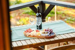 a table with a bottle of wine and a plate of food at Romantic luxury tiny home in an idyllic setting in Glenquarry