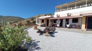 a building with a yard with rocks and a building at Gavdos Panorama in Gavdos