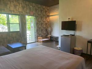 a bedroom with a bed and a television in it at Pet Truelove in Hengchun South Gate
