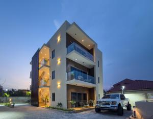 a white truck parked in front of a building at Serenity Suite in Accra