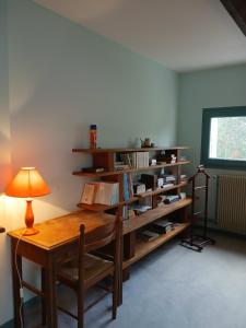 a room with a table with a lamp and a book shelf at Boningal in Moissac
